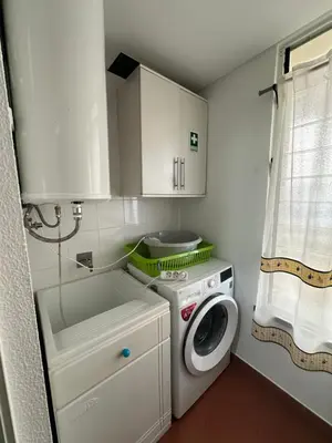 a small kitchen with a washing machine and a washer at Refugio do Ferreirinha in Caniço