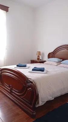 a bedroom with a large wooden bed with towels on it at Yellow Owl II Bedroom I in Campanário