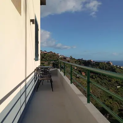 a balcony with a table and bench on the side of a building at Yellow Owl II Bedroom I in Campanário