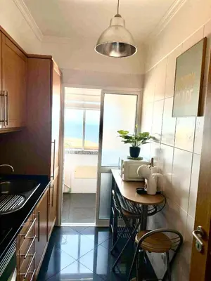 a small kitchen with a table and a window at A&CSuite in Caniço