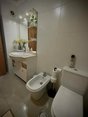 a white bathroom with a toilet and a sink at A&CSuite in Caniço