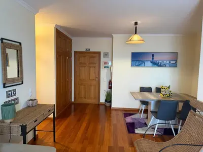a living room with a table and chairs and a dining room at A&CSuite in Caniço