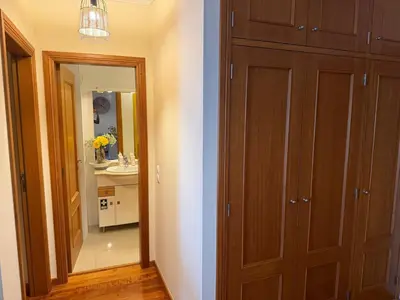 a bathroom with a large wooden closet and a mirror at A&CSuite in Caniço