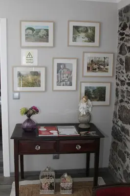 a room with a table with pictures on the wall at A Casa da Carolina in São Vicente