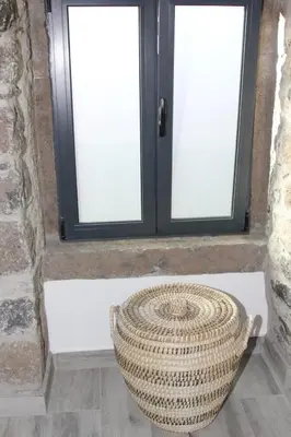a window with a basket sitting in front of it at A Casa da Carolina in São Vicente