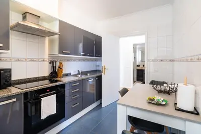 a kitchen with black and white cabinets and a table at GuestReady - Ocean breeze retreat in Santa Cruz