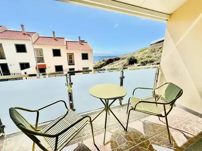 a balcony with two chairs and a table at Casa da Minha Luz in Santa Cruz