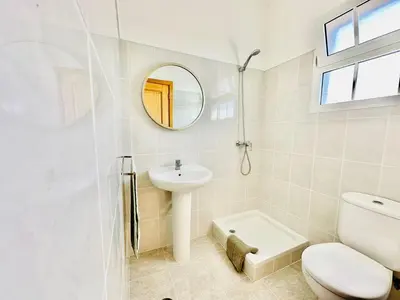 a bathroom with a toilet and a sink and a mirror at Casa da Minha Luz in Santa Cruz