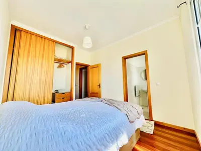 a bedroom with a large bed and a mirror at Casa da Minha Luz in Santa Cruz