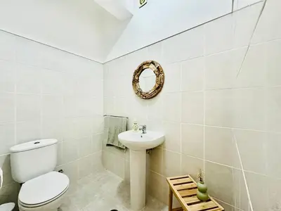 a bathroom with a toilet and a sink and a mirror at Casa da Minha Luz in Santa Cruz