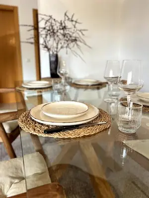 a glass table with a plate and glasses on it at Casa Solaris Algarve in Burgau