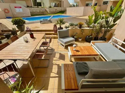 an outdoor patio with tables and chairs and a pool at Casa Solaris Algarve in Burgau