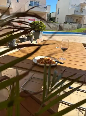 a table with a plate of food and a glass of wine at Casa Solaris Algarve in Burgau
