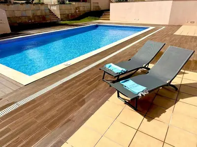 a swimming pool with a chair next to a swimming pool at Casa Solaris Algarve in Burgau