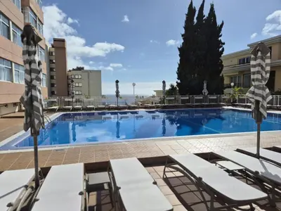 a swimming pool in a hotel with lounge chairs at Hotel Bunganvilia in Funchal