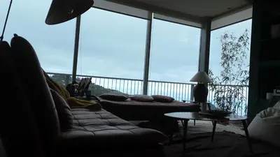 a living room with a couch and large windows at Keam House in Santana