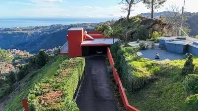 a small red building on a hill with a road at Keam House in Santana