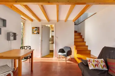 a living room with wooden ceilings and a staircase at Romantic Retreat by Slice of Heaven in Jardim do Mar