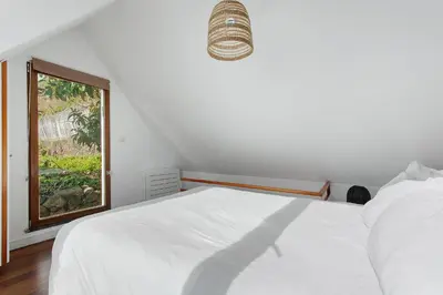 a bedroom with a white bed and a window at Romantic Retreat by Slice of Heaven in Jardim do Mar