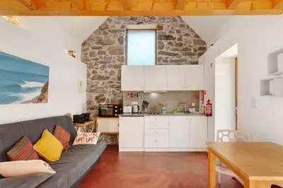 a kitchen and living room with a couch and a table at Romantic Retreat by Slice of Heaven in Jardim do Mar