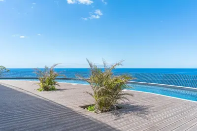 a swimming pool next to the ocean on a beach at Xavelha Clifftop by Atlantic Holiday in Câmara de Lobos