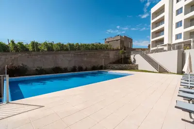 a swimming pool in the backyard of a building at Sunset Luxury Apartment by Amazing Madeira in Câmara de Lobos