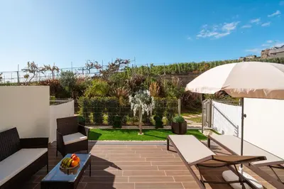 a patio with a table and chairs and an umbrella at Sunset Luxury Apartment by Amazing Madeira in Câmara de Lobos