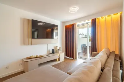 a living room with a couch and a large window at Sunset Luxury Apartment by Amazing Madeira in Câmara de Lobos