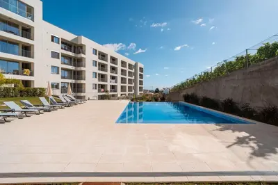 a swimming pool in front of a building at Sunset Luxury Apartment by Amazing Madeira in Câmara de Lobos