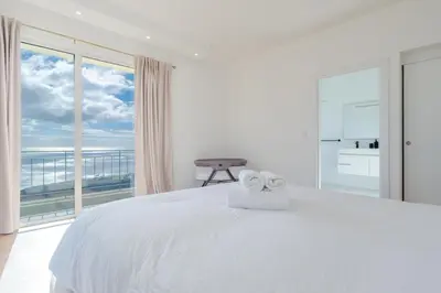 a white bedroom with a large bed and a large window at Skyline Villa by Holiday Rental Madeira in Gaula