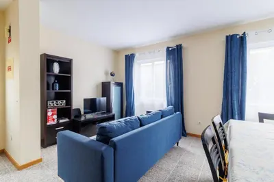 a living room with a blue couch and a tv at Santana Lens & Trail House in Santana