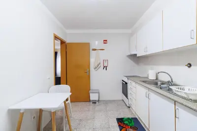 a white kitchen with a sink and a table at Santana Lens & Trail House in Santana