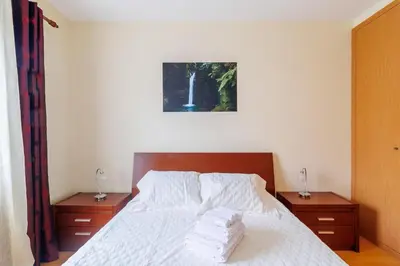 a bedroom with a white bed with two nightstands and a picture at Santana Lens & Trail House in Santana