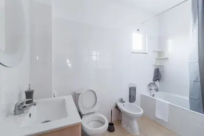 a white bathroom with a toilet and a sink at Santana Lens & Trail House in Santana