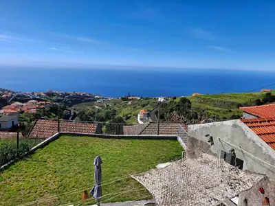 a view of the ocean from a balcony of a house at Casa Rosinha, vistas, por-do-sol e conforto in Calheta