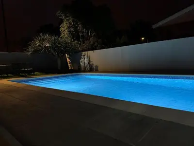 a large blue swimming pool at night at Villa Canhas in Canhas