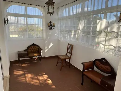 a living room with two chairs and two windows at Villa Canhas in Canhas
