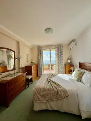 a bedroom with a large bed and a large window at Apartamento Precioso in Arco da Calheta