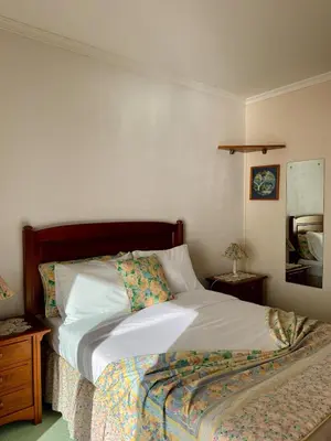 a bedroom with a bed and a table with a night stand at Apartamento Precioso in Arco da Calheta