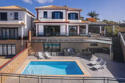 a large house with a swimming pool in front of it at New Casa Bondi by Your Madeira Rentals in Ponta do Sol