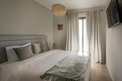a bedroom with a large white bed and a window at New Casa Bondi by Your Madeira Rentals in Ponta do Sol