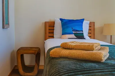 a bedroom with a bed with a blue pillow at NEW Villa 66 - Palheiro Village by YMR in São Gonçalo