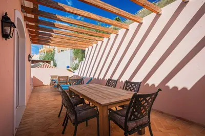 a dining room with a wooden table and chairs at NEW Villa 66 - Palheiro Village by YMR in São Gonçalo