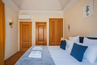 a bedroom with a large bed with blue and white pillows at NEW Villa 66 - Palheiro Village by YMR in São Gonçalo