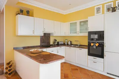 a kitchen with white cabinets and a counter top at NEW Villa 66 - Palheiro Village by YMR in São Gonçalo