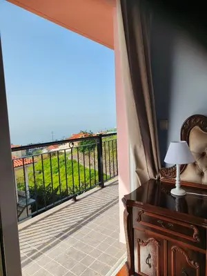a bedroom with a balcony with a view of the ocean at Golden Sun Refugio in Estreito da Calheta