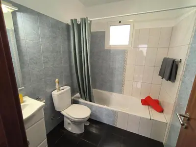 a bathroom with a toilet and a tub and a sink at Golden Sun Refugio in Estreito da Calheta