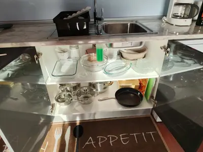 a kitchen counter with a sink and shelves with dishes at Golden Sun Refugio in Estreito da Calheta
