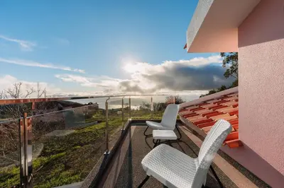 a bedroom with a crib and a flat screen tv at Cantinho do Céu, Views, Peace, Comfort & BBQ in Ribeira Brava