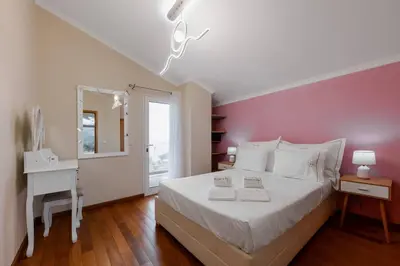 a bedroom with a large white bed with two night stands at Cantinho do Céu, Views, Peace, Comfort & BBQ in Ribeira Brava